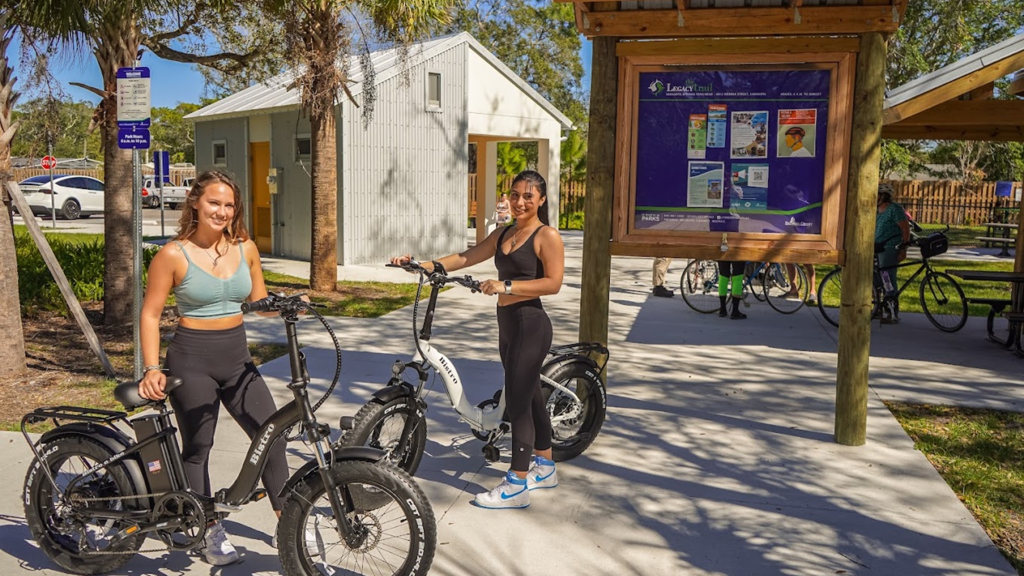 women standing next to ebikes